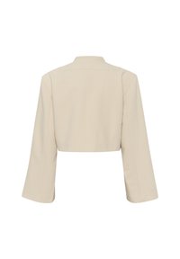 Gekürzter beiger Blazer mit strukturiertem Design. Merkmale sind weite Glockenärmel und ein minimalistischer Kragen. Glatte, maßgeschneiderte Stofftextur.