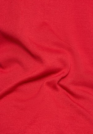 Roter Strickstoff mit einer strukturierten Oberfläche, der Falten und Knicke aufweist und so Tiefe und visuelles Interesse erzeugt.