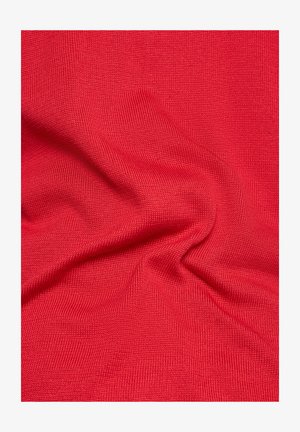 Roter Strickstoff mit einer strukturierten Oberfläche, der Falten und Knicke aufweist und so Tiefe und visuelles Interesse erzeugt.