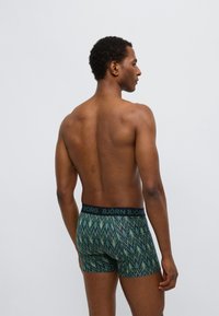 Zelené boxerky s vzorem a černým pasem s nápisem "BJÖRN", zdobené cikcak vzorem a s přiléhavým střihem.