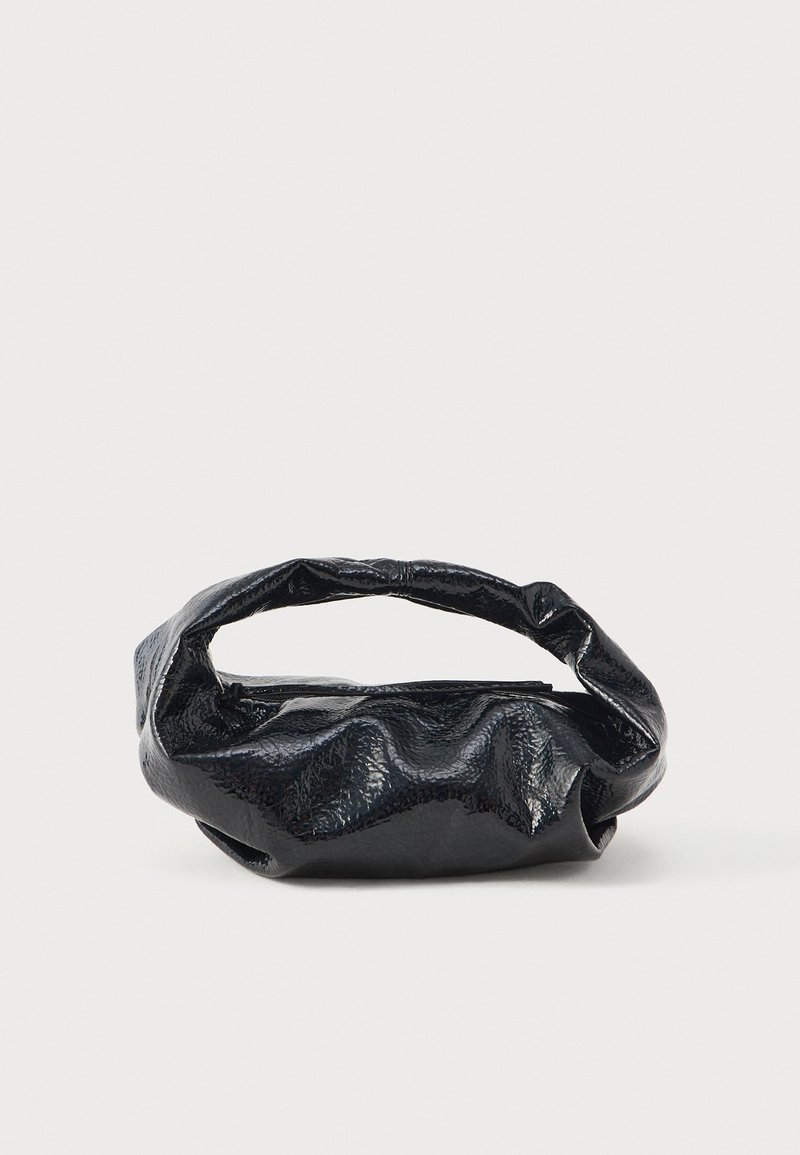 Saco preto feito de material brilhante e texturizado, com uma pega circular torcida e fecho zip. Apresenta um design suave e enrugado.