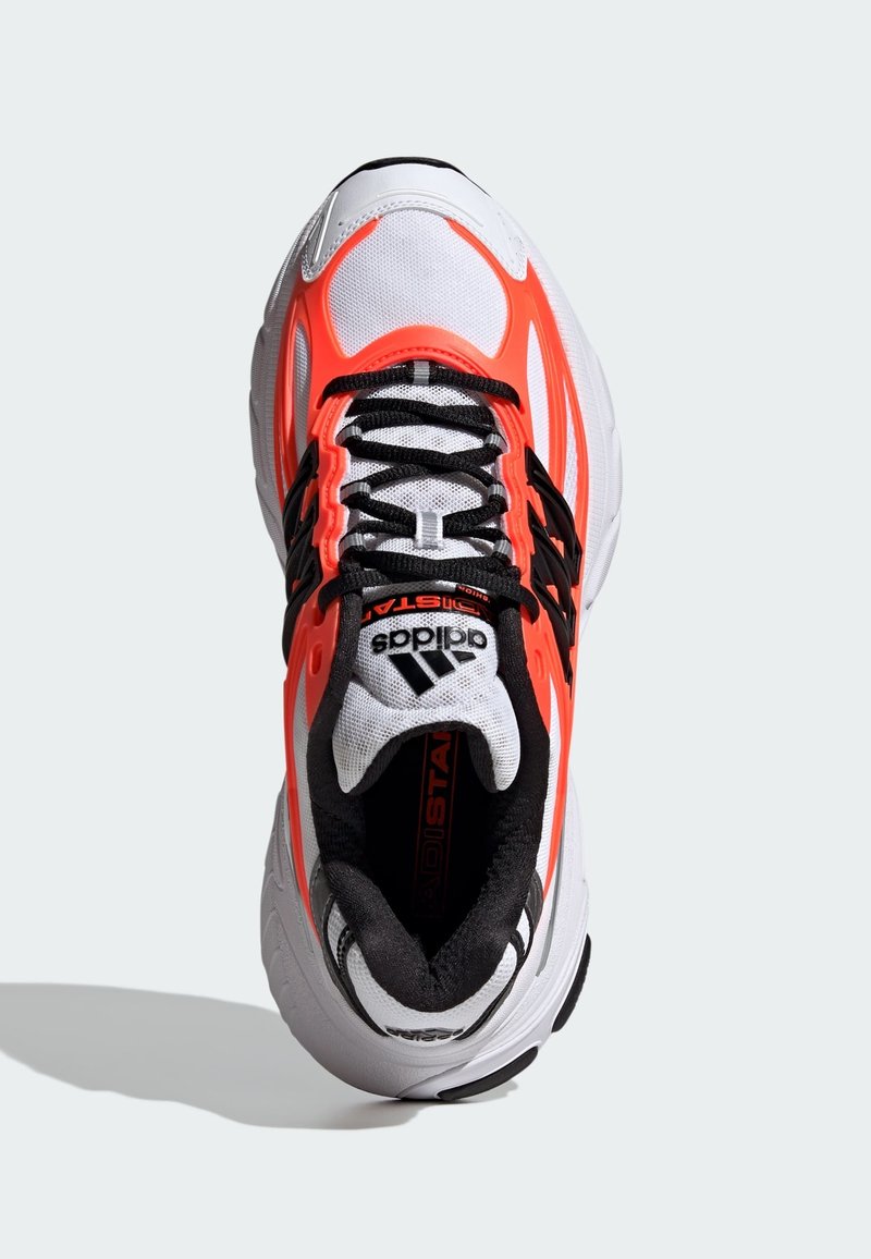 Løbesko med en hvid mesh-overdel, sorte detaljer og klare orange overlays. Har en polstret krave og sorte snørebånd.