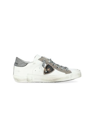 Sneaker bianca e grigia con un tallone grigio strutturato, lacci con motivo e un emblema di lato; leggermente usata con una suola in gomma.