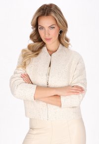 Kurze, cremefarbene Bomberjacke mit strukturiertem Webmuster und Reißverschluss. Sie hat gerippte Bündchen und eine verkürzte Silhouette für eine taillierte Passform.