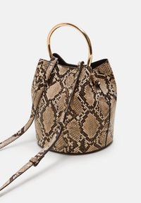 Sac seau à motif peau de serpent marron et crème avec une anse en métal doré en forme d'anneau et une bandoulière tissée amovible. Extérieur texturé.