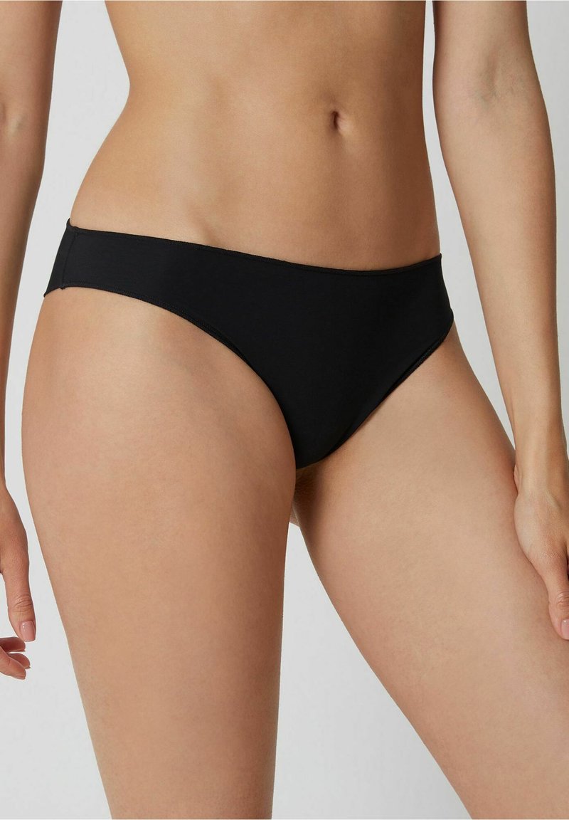 Schwarzer Bikiniunterteil mit einem stromlinienförmigen Design, hergestellt aus glattem, dehnbarem Stoff. Er hat einen niedrigen Schnitt mit minimaler Abdeckung und sauberen Kanten.