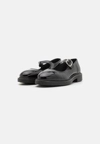Black patent leather Mary Jane shoes featuring a rounded toe, adjustable buckle strap, and flat sole with minimal detailing.