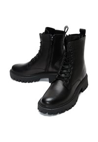 Bottes de combat en cuir noir avec un laçage à l'avant et une fermeture éclair sur le côté. Présente une semelle en caoutchouc texturée et une cheville rembourrée pour le confort.