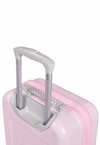 Rosa hårdskalväska med ett grått handtag, texturerad dragkedja och dubbla metallhjul. Inkluderar ett förvaringsutrymme för extra saker.