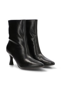 Botas de cuero negras hasta el tobillo con punteras afiladas y tacones delgados, mostradas una al lado de la otra sobre un fondo blanco.