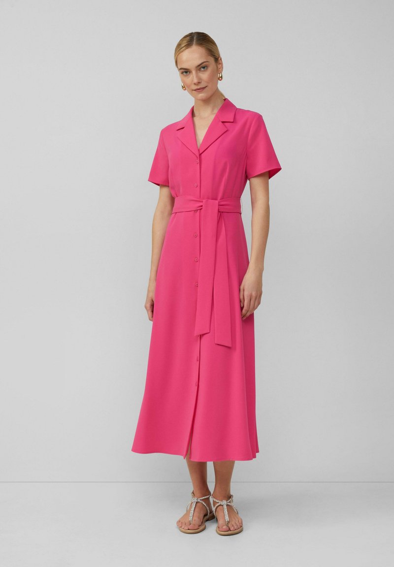 Fuchsia midi-jurk met korte mouwen, knoopsluiting aan de voorkant, een ceintuur op de taille en een rechte pasvorm. Gladde stof met een subtiele glans.