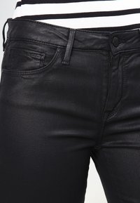 Svarta denimjeans med slim fit, med en mjuk textur, femfickorsdesign och knappstängning i midjan.