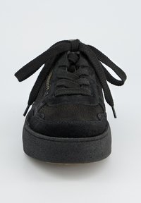 Baskets noires avec un dessus en daim texturé, lacets plats noirs, col rembourré et une épaisse semelle en caoutchouc noir. Comprend une fermeture éclair sur le côté.