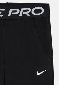 Black athletic pants with a ribbed texture, featuring a flat waistband embossed with "PRO" in white and a white Nike swoosh logo.