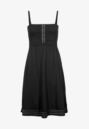 Zwarte mouwloze jurk met een getailleerd lijfje, geplooide details en een uitlopende rok. Voorzien van witte stiksels nabij de zoom en verticale accenten.