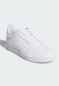 White athletic shoes made of synthetic material, featuring three lateral stripes, a smooth texture, and a low-profile rubber sole.