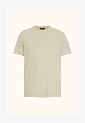 Enkelt creme-farvet kortærmet bomulds-T-shirt med rund hals og et lille sort mærke på bagsiden af kraven indvendigt.