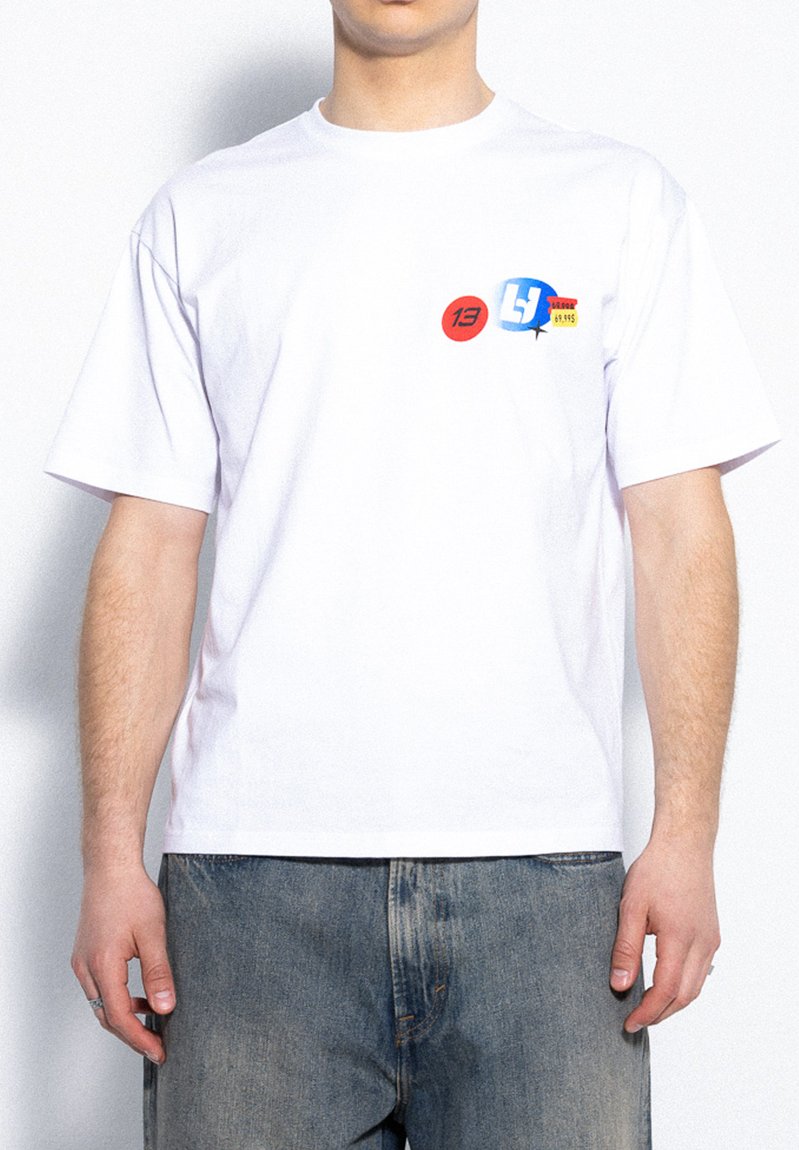 Biała bawełniana koszulka z krótkim rękawem z trzema kolorowymi okrągłymi grafikami: czerwoną z "13", niebieską z literami i żółtą z kodem kreskowym.