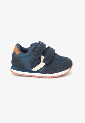 Marineblauwe sneaker met twee klittenbandsluitingen, gemaakt van suede en gaas, witte tussenzool, oranje hielaccent en een gestructureerde rubberen loopzool.