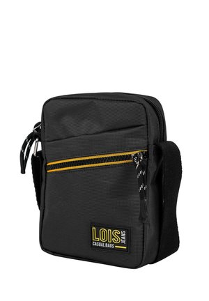 Bolso bandolera de nylon negro con cremallera con detalles en amarillo, superficie texturizada, parche con logotipo frontal y correa ajustable. Diseño compacto y funcional.