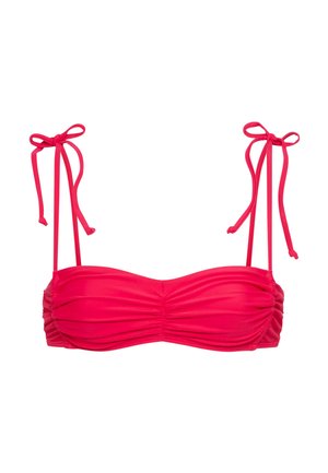 Punane bikiniülaõlg rušitud kangaga ja õhukeste paeltega, mis on valgel taustal vibu sisse seotud.