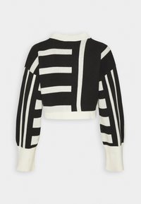 Pull en maille noir et blanc coupé, à manches longues, avec un motif géométrique à rayures au dos et sur les manches.