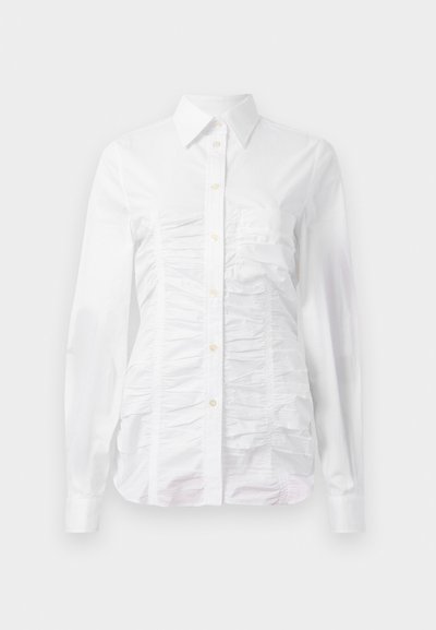White button-up shirt with long sleeves, featuring a ruched texture across the front, small golden buttons, and a standard collar.