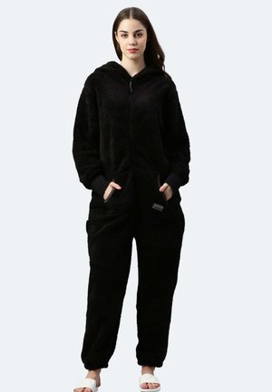 Schwarzer Fleece-Overall mit Kapuze, frontalen Taschen und elastischen Bündchen. Strukturierter Stoff, Reißverschluss und ein Logo-Detail auf der Tasche.