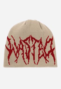 Gorro beige de punto con un diseño gráfico rojo. El patrón de texto se asemeja a letras dentadas, con un ajuste ceñido y una textura suave.