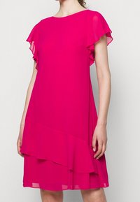 Fuchsia dress with short ruffled sleeves, made of lightweight fabric. Features a layered hem design and a simple round neckline.