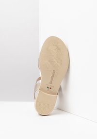 Beige Sandale mit einer gemusterten Gummisohle, metallischen Gurtakzenten und einem „Made in Italy“-Label. Größe 37 auf der Innensohle aufgedruckt.