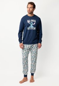 Sudadera azul marino con el texto "ALOHA STITCH" y un personaje de dibujos animados; pantalones de pijama con un patrón en tejido ligero, que presentan acentos y diseños en azul.