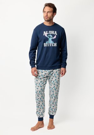 Sudadera azul marino con el texto "ALOHA STITCH" y un personaje de dibujos animados; pantalones de pijama con un patrón en tejido ligero, que presentan acentos y diseños en azul.
