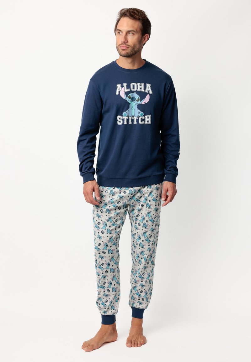 Sudadera azul marino con el texto "ALOHA STITCH" y un personaje de dibujos animados; pantalones de pijama con un patrón en tejido ligero, que presentan acentos y diseños en azul.