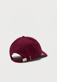 Bordo medvilnės kepurė su lenktu kraštu, audiniu dengtą mygtuką ir reguliuojamu metaliniu užsegimu gale. Minkšta tekstūra, paprastas dizainas.