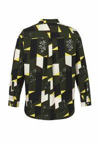 Button-up shirt featuring a geometrical pattern in green, black, white, and yellow, with leopard print accents and long sleeves.
