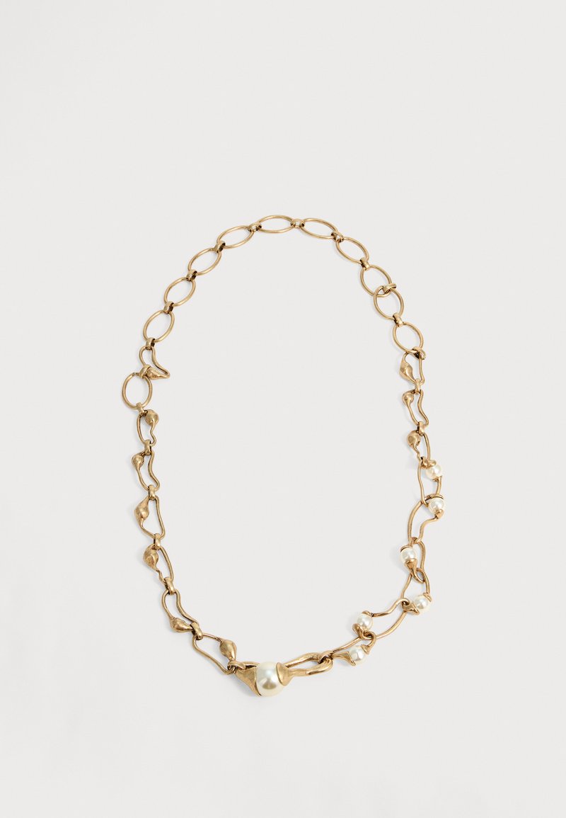 Collier chaîne en or avec des maillons irréguliers et de petites perles blanches espacées sur un côté, présenté sur un fond clair uni.