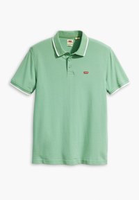 Polo vert avec des accents blancs, à manches courtes et un col à trois boutons. Présente un petit logo rouge sur la poitrine gauche. En matière de coton.