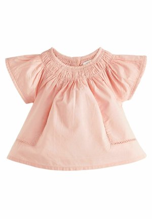 Blusa di cotone rosa chiaro con scollo arricciato, maniche corte a sbuffo e cuciture decorative lungo l'orlo e le tasche.