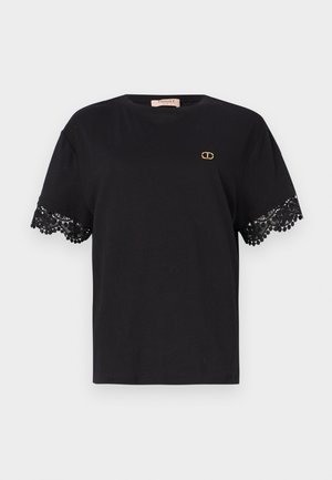 Camiseta de algodón negra con mangas cortas y un intrincado borde de encaje. Pequeño detalle del logo dorado en el pecho. Textura suave y lisa.