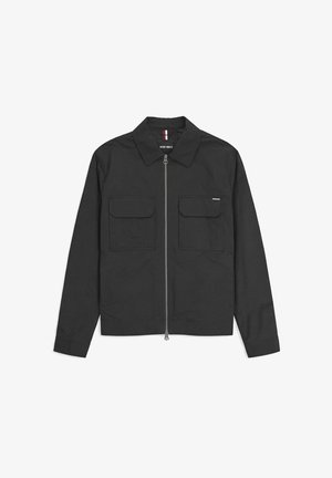 Zwarte lange mouwen jas met ritssluiting aan de voorkant, twee borstzakken met klep en een puntige kraag, plat gelegd op een witte achtergrond.