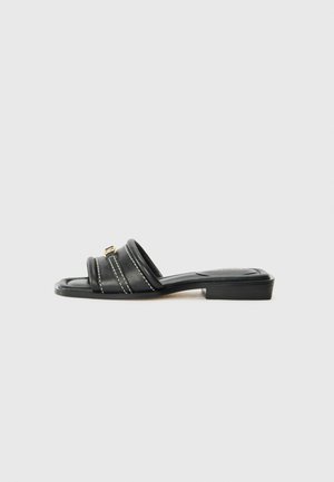 Black leather slide sandals with two horizontal straps, white stitching, and a rectangular flat sole. Features a small gold accent on the front.