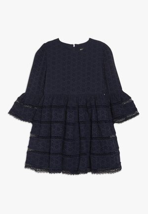 Granatowa sukienka z lekkiego materiału, zdobiona kwiatową haftem, z falbankowymi rękawami i warstwowym krojem z koronkową lamówką na dole.