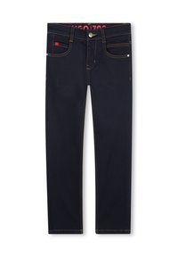 Jeans de mezclilla azul oscuro con costuras amarillas en contraste, cinco bolsillos y cierre de botón plateado. Presenta una etiqueta de marca roja en la cinturilla.