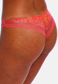 Roze kanten slipjes met bloemenborduursel op de achterkant, gekenmerkt door verfijnde stiksels en een delicate scalloped rand.