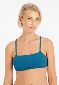 Zelenomodrý bikiny top s textúrovaným, cik-cak vzorom. Obsahuje tenké ramienka a štvorcový strih, ktorý zdôrazňuje moderný, minimalistický štýl.