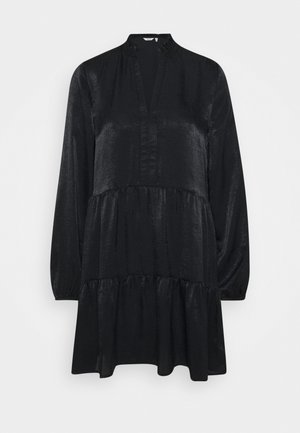 Vestido negro de manga larga con volantes, cuello alto y abertura en V, hecho de una tela texturizada ligeramente brillante.