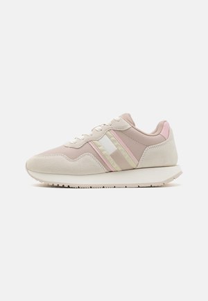 Zapatillas deportivas en tonos beige y rosa, con texturas de ante y sintético, franjas prominentes y una suela ligera, diseñadas para la comodidad.