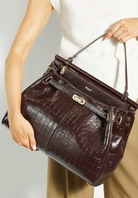 Brown crocodile-patterned leather tote bag with dual handles, gold hardware accents, and a zippered top. Features a detailed embossed logo.