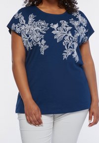 Mörkblå kortärmad topp med vit blommönstring fram. Har en avslappnad passform och mjuk textur, lämplig för avslappnad klädsel.